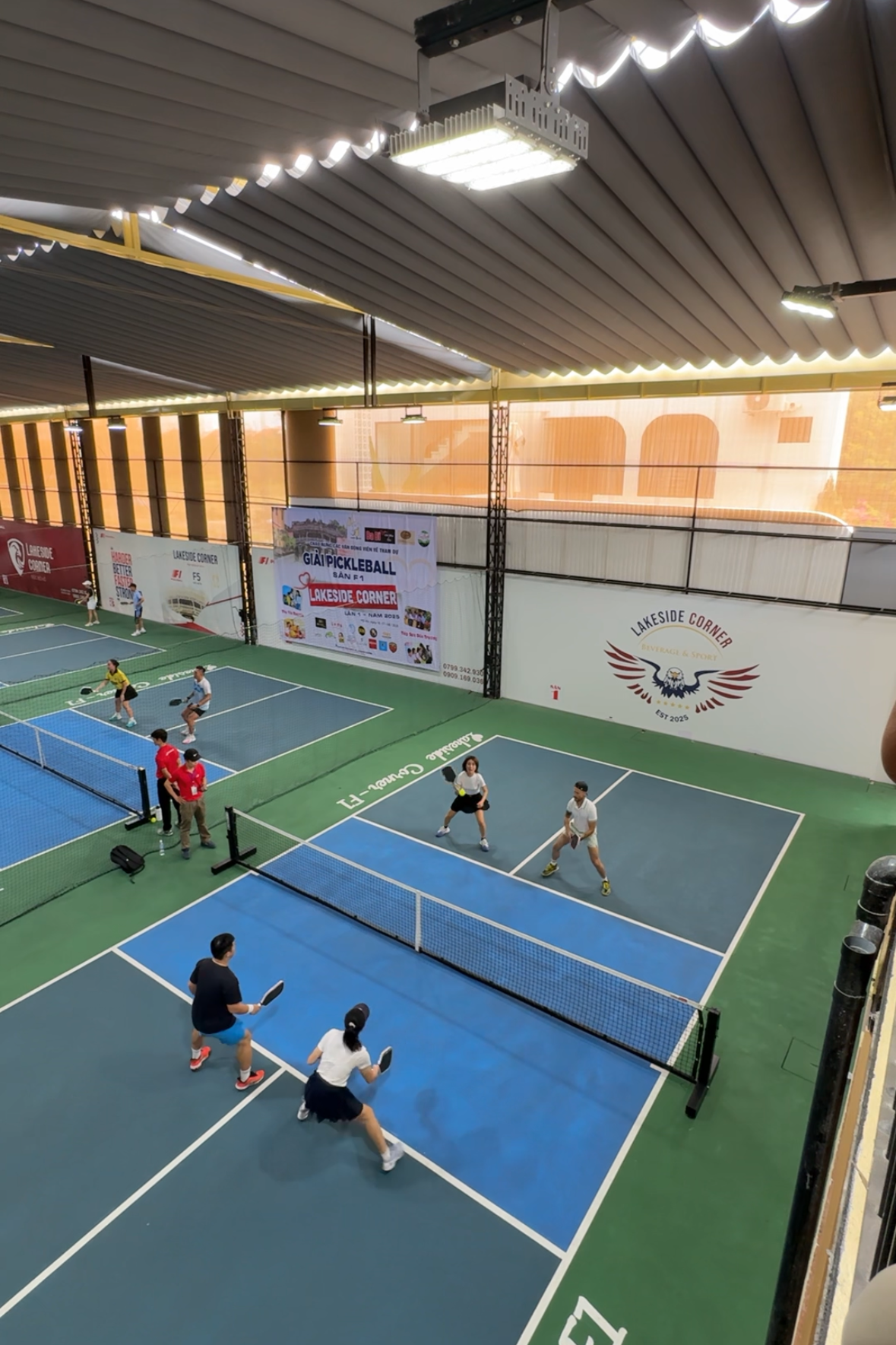 Indoor pickleball court with players on a blue court