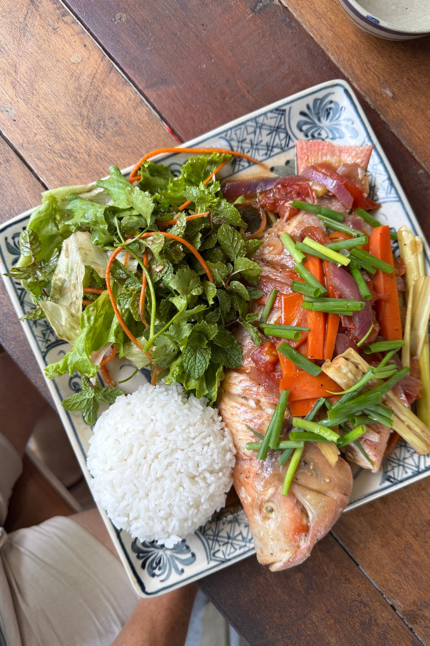 Farm to table dish with fish, vegetables, and rice on a wooden table