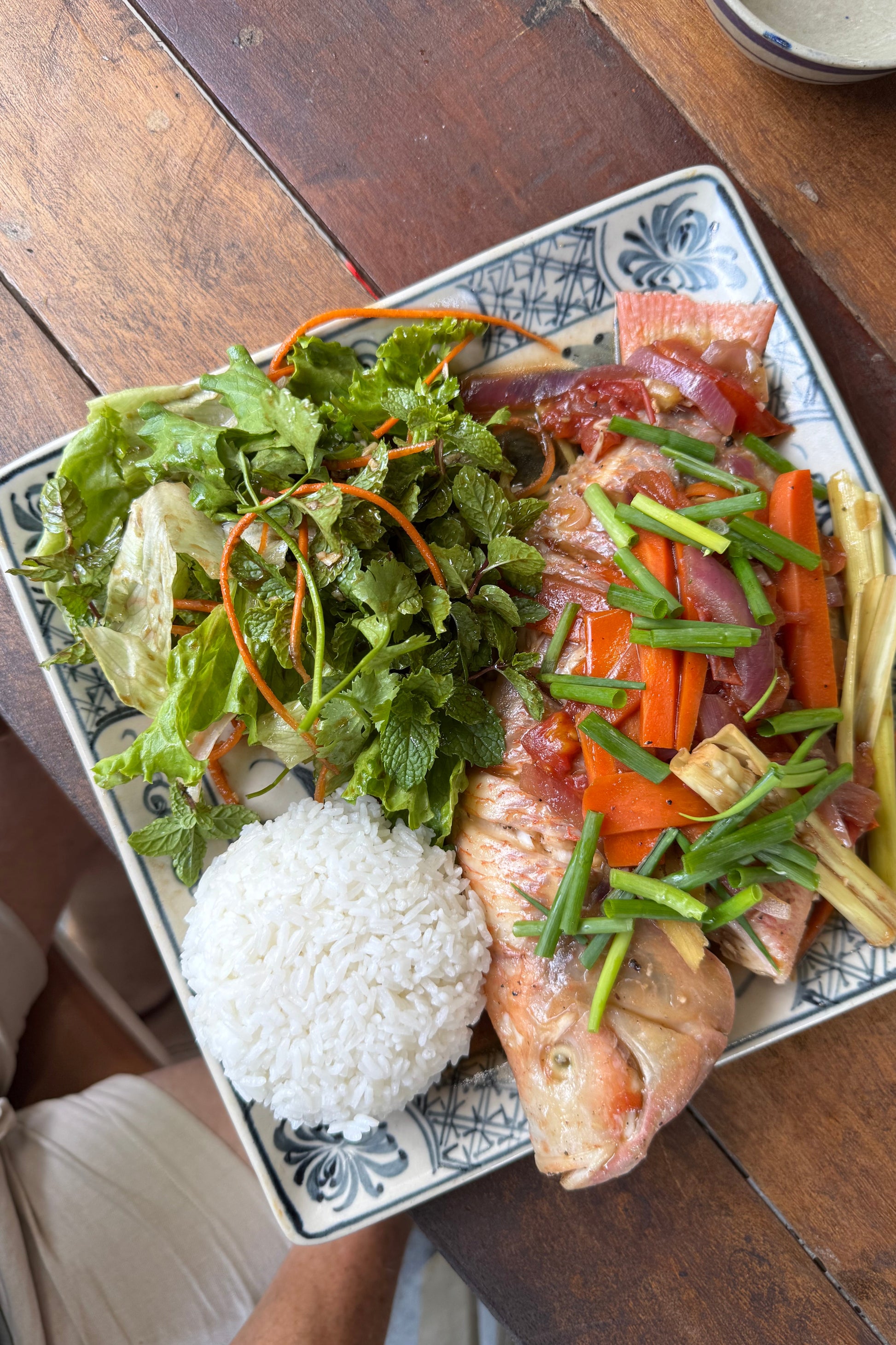 Farm to table dish with fish, vegetables, and rice on a wooden table