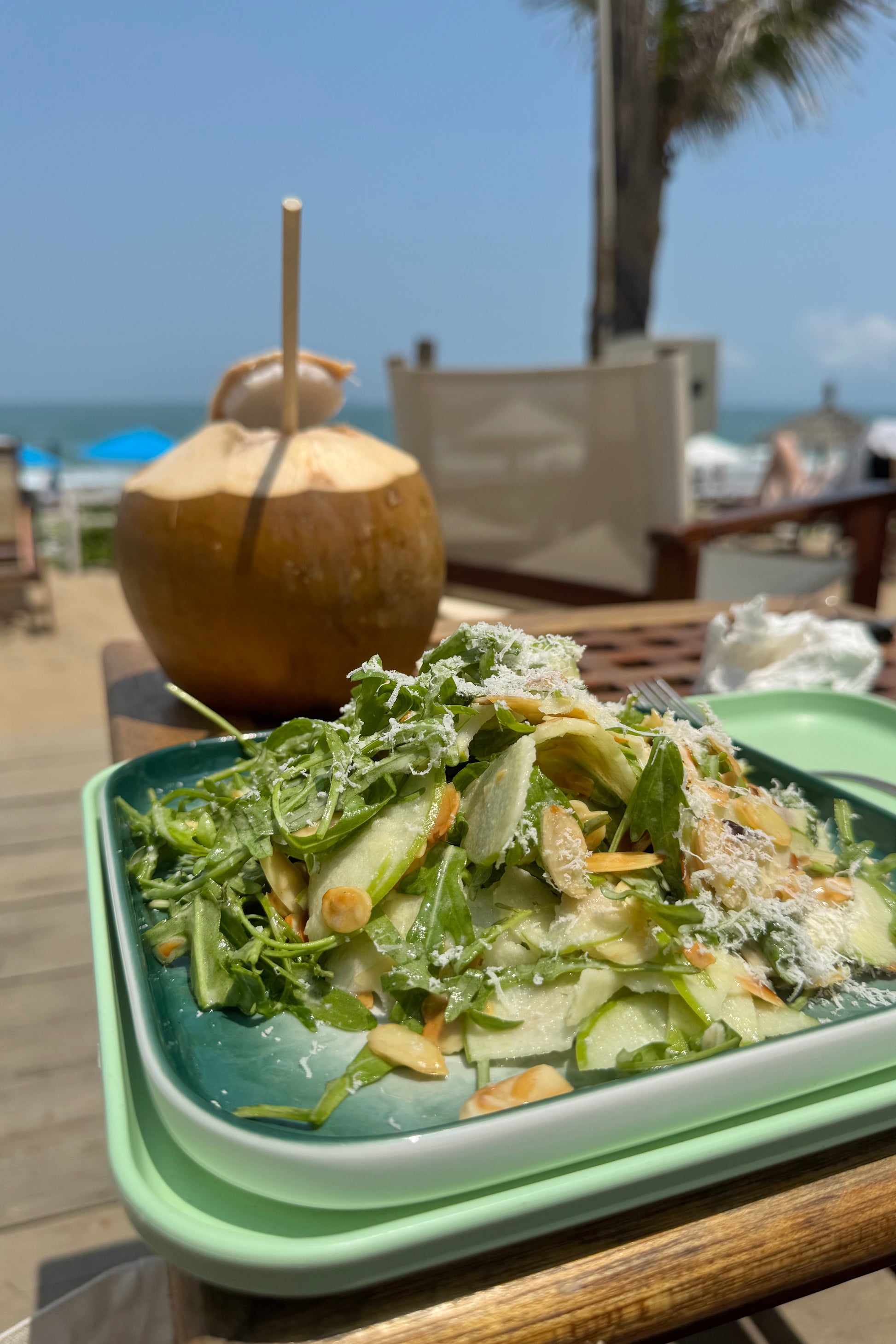 Salad in a green container with a blurred outdoor background