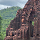 Person standing on ancient brick ruins with greenery in the background